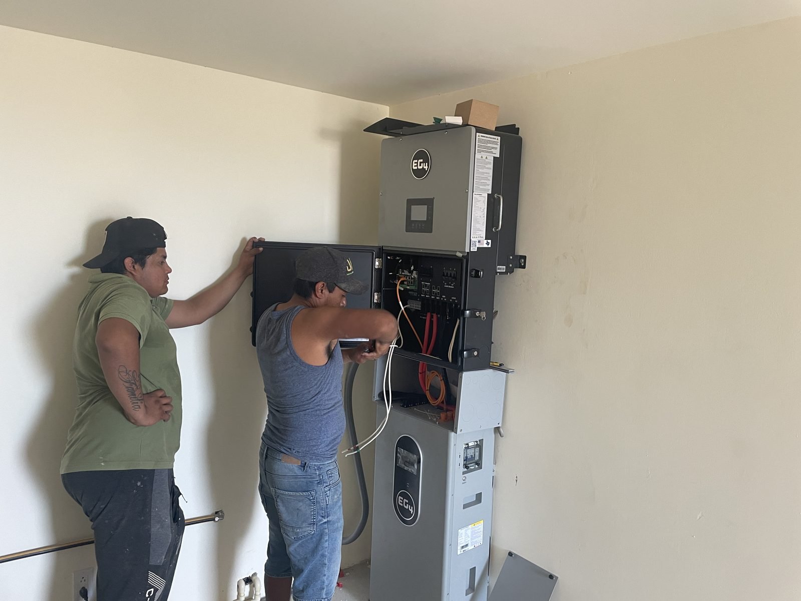 Solar battery backup for Los Cabos blackouts: technicians installing a hybrid inverter and battery indoors